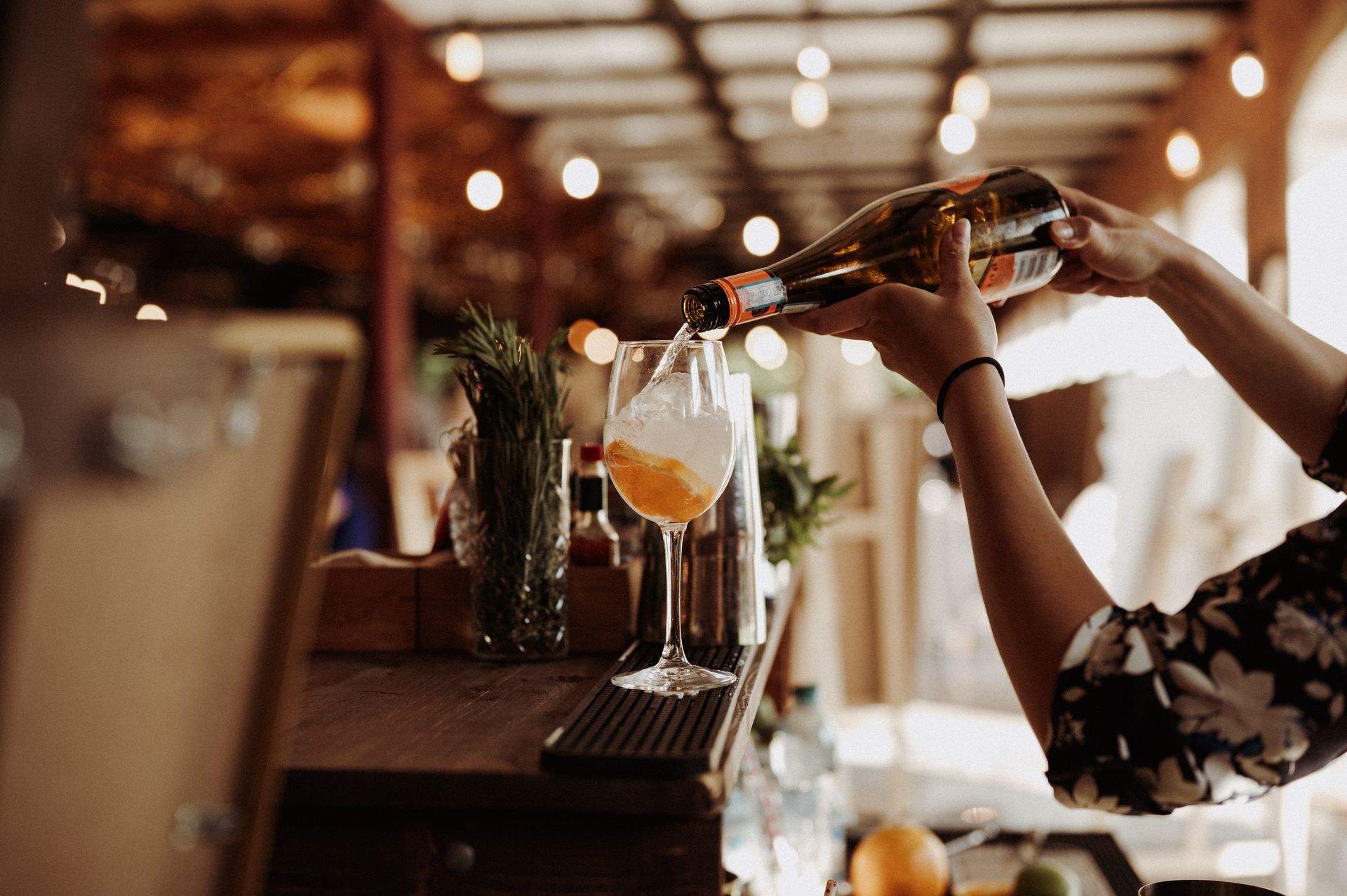 Barman nalewający drinki przy barze w ciepłym, wieczornym świetle